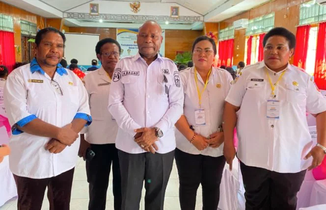 Agustinus Bagau berdiri bersama empat orang berseragam putih di aula pelatihan