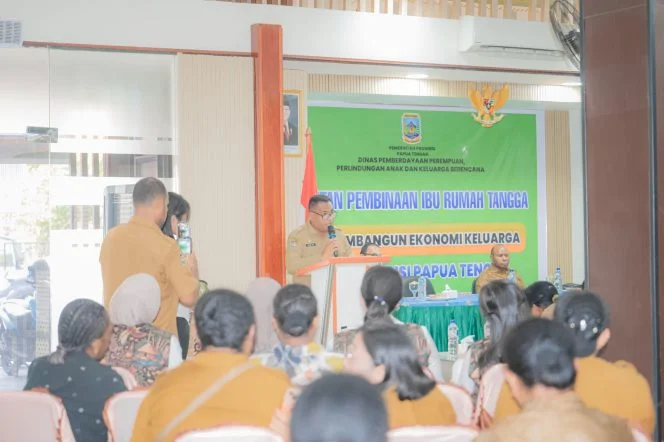 Pembicara berseragam dinas berbicara di podium di depan spanduk Pembinaan Ibu Rumah Tangga, peserta duduk menyimak