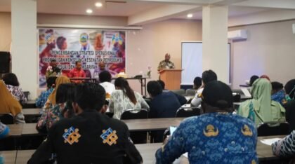 Peserta duduk menghadap pembicara di podium, di depan spanduk Pengembangan Strategi Operasional Promosi dan Konseling Kesehatan Reproduksi